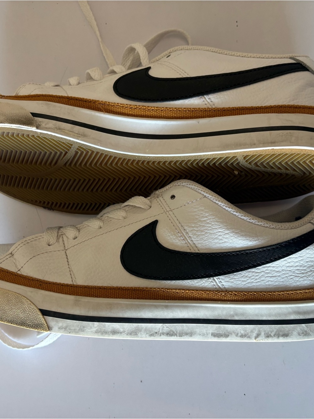 Nike Men’s White Leather Sneakers with Black Swoosh and Gold Accent